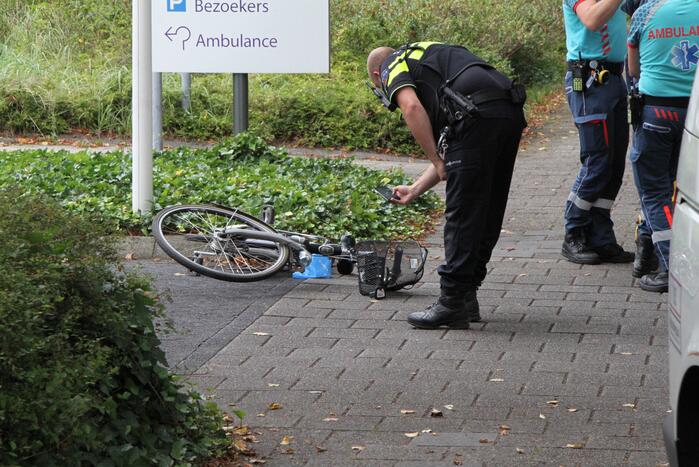 Vrouw met fiets gaat onderuit voor ingang ziekenhuis