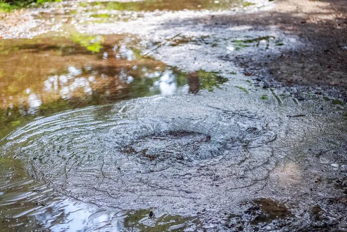 Putdeksel komt omhoog en zorgt voor wateroverlast op bospad