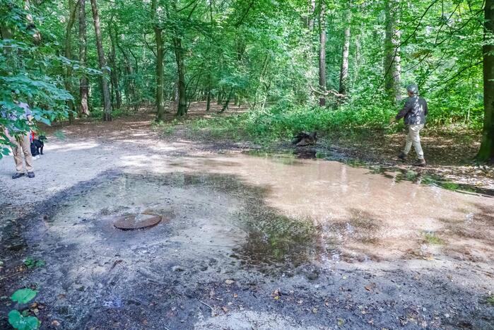 Putdeksel komt omhoog en zorgt voor wateroverlast op bospad