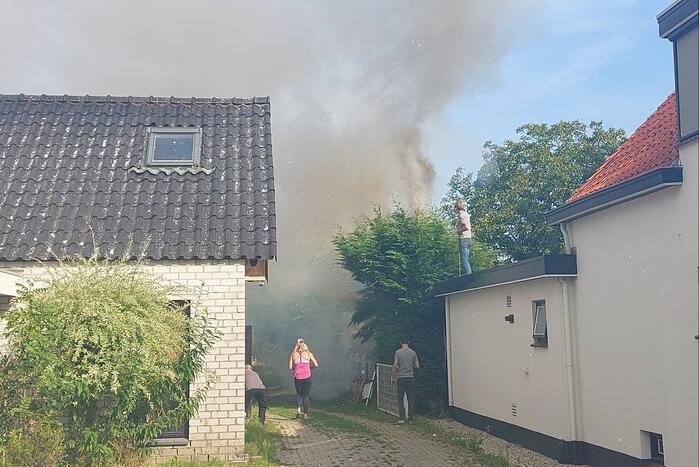 Coniferenhaag vliegt in brand in achtertuin