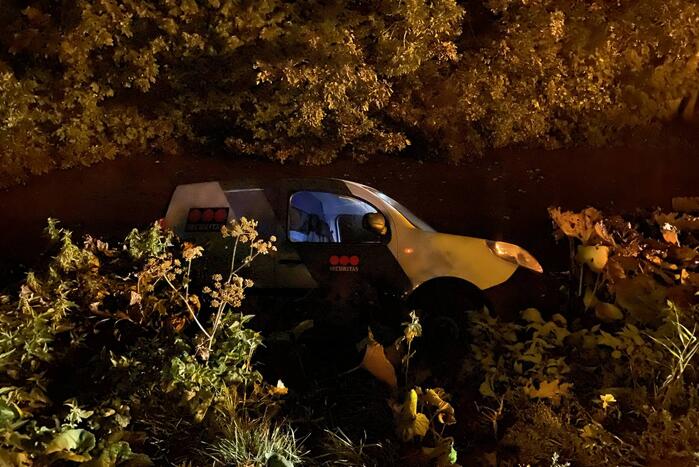 Beveiligingsbus rolt achteruit het water in