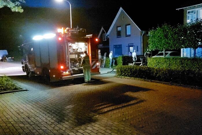 Brandweer blust brand aan achterzijde van woning