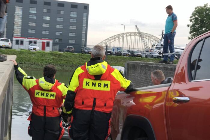 Omgeslagen boot wordt opgetakeld in jachthaven