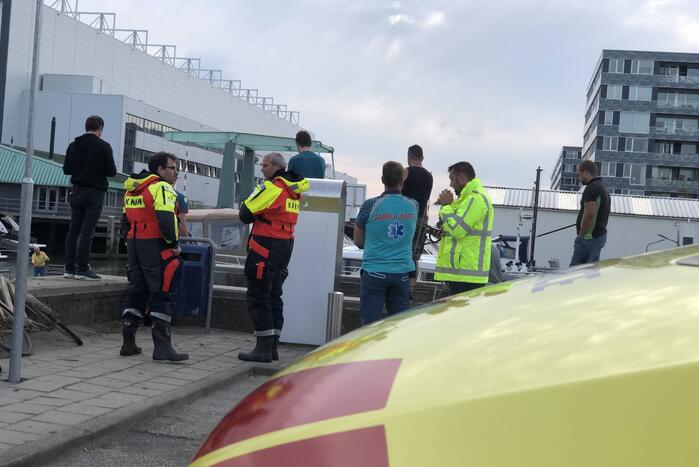 Omgeslagen boot wordt opgetakeld in jachthaven