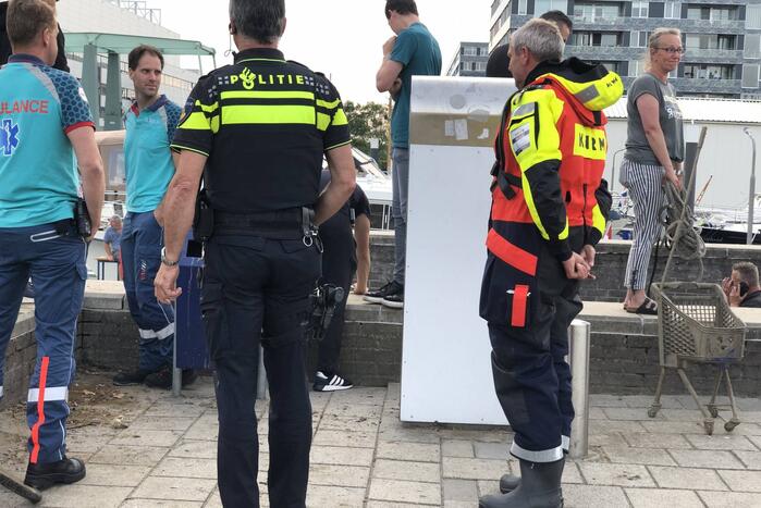 Omgeslagen boot wordt opgetakeld in jachthaven