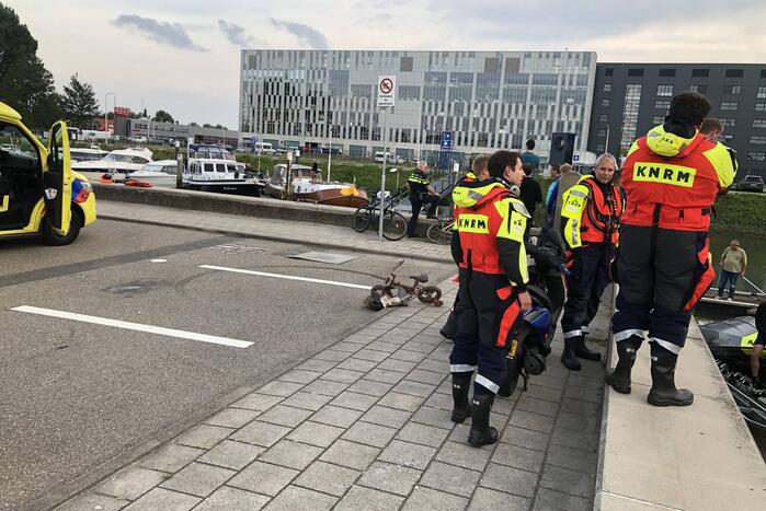 Omgeslagen boot wordt opgetakeld in jachthaven