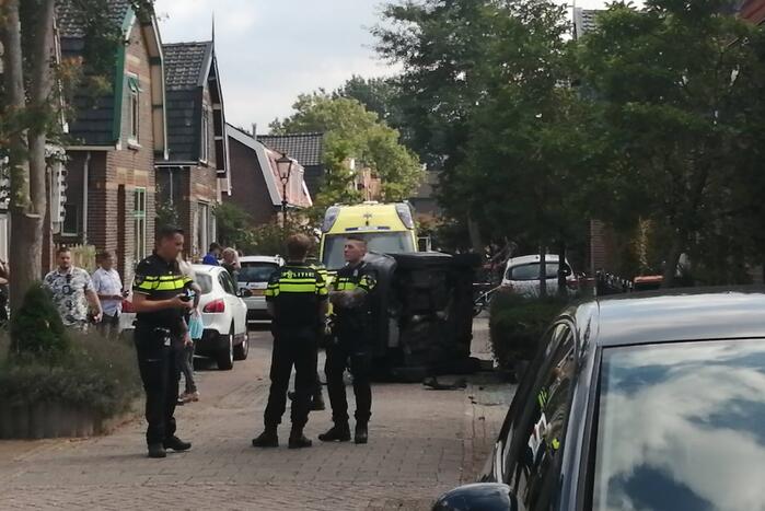 Personenauto belandt op zijn zijkant in woonwijk