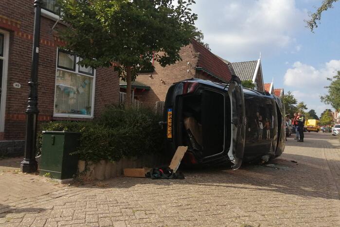 Personenauto belandt op zijn zijkant in woonwijk