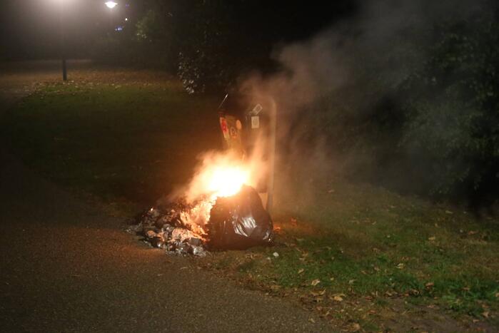 Brandweer blust brand bij prullenbak