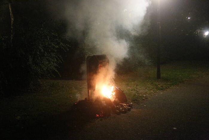 Brandweer blust brand bij prullenbak