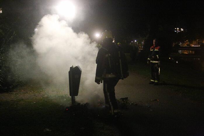 Brandweer blust brand bij prullenbak