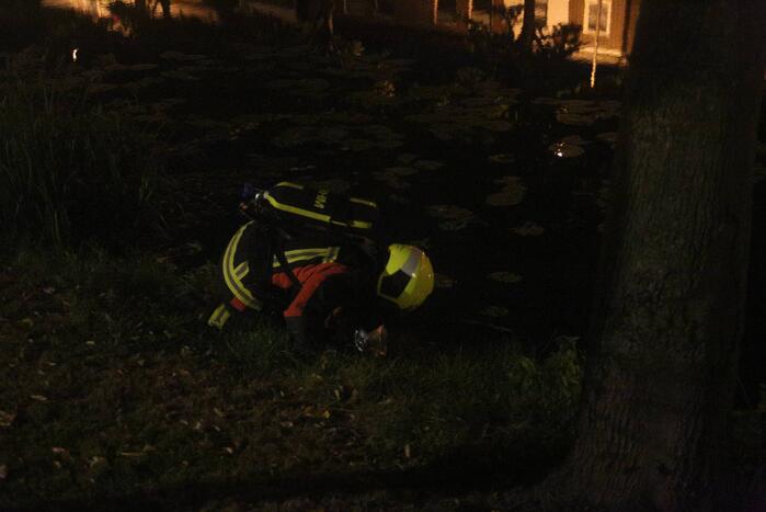 Brandweer blust brand bij prullenbak