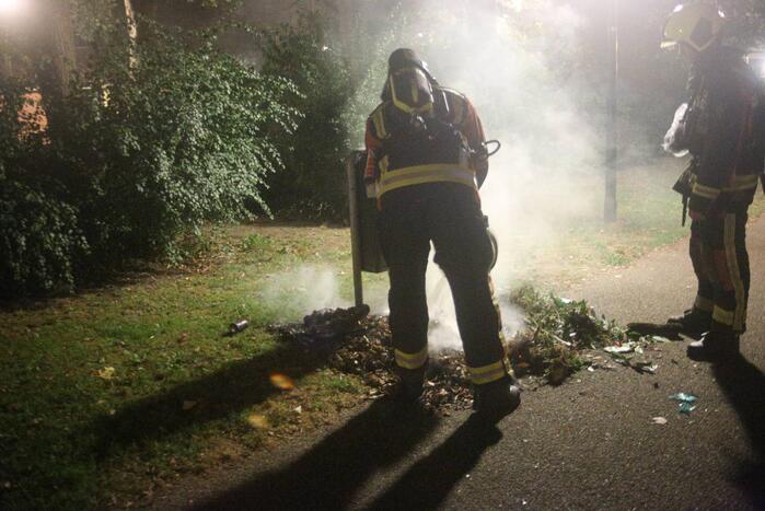 Brandweer blust brand bij prullenbak