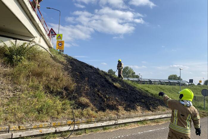 Berm talud naast snelweg vat vlam
