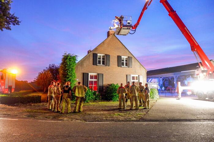 Brandweer blust brand in schoorsteen bij boerderij