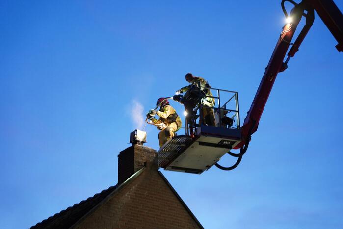 Brandweer blust brand in schoorsteen bij boerderij