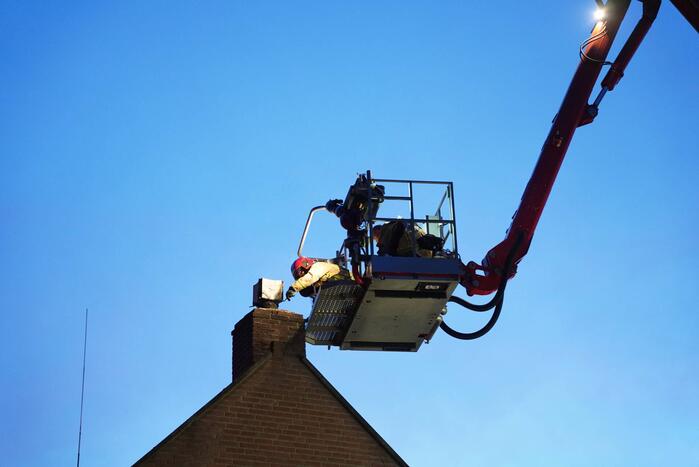 Brandweer blust brand in schoorsteen bij boerderij