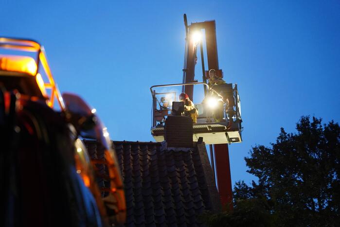 Brandweer blust brand in schoorsteen bij boerderij
