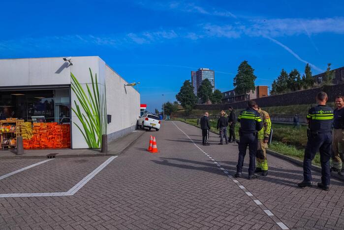 Auto rijdt tegen gevel Esso-tankstation aan