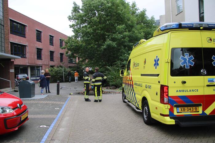 Vrouw botst met auto op gevel van wooncomplex