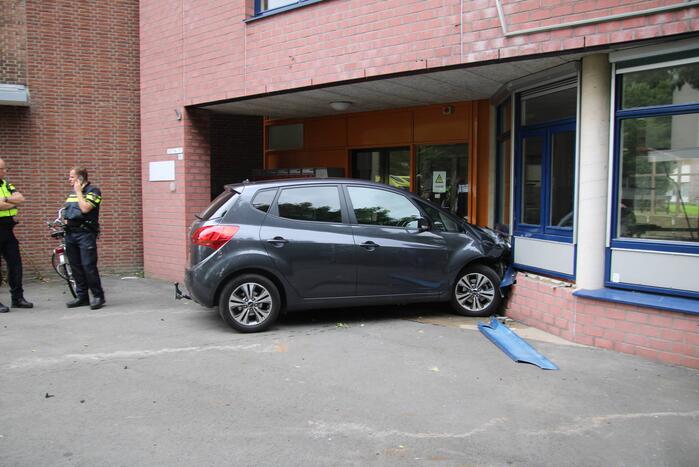 Vrouw botst met auto op gevel van wooncomplex