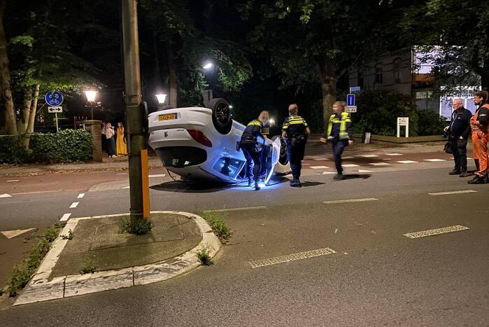 Auto op zijn kop tot stilstand na botsing tegen paal