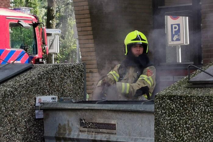Brandweer blust brand in papiercontainer