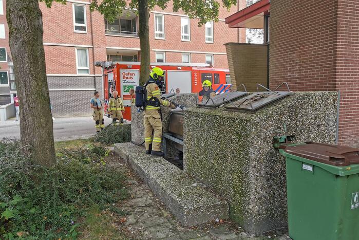 Brandweer blust brand in papiercontainer