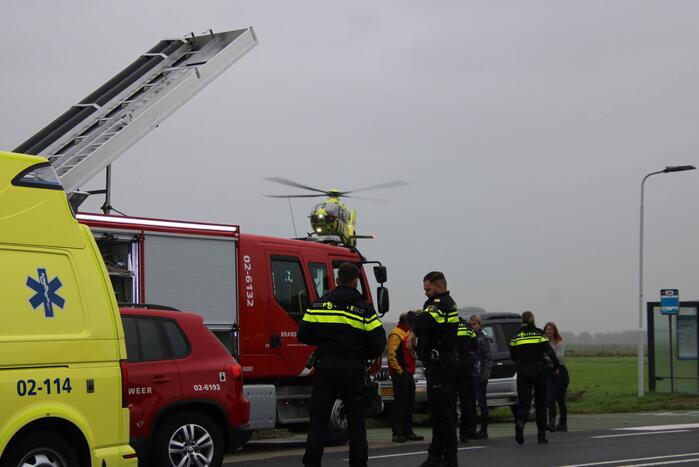 Auto raakt na botsing van de weg en belandt op de kop in weiland