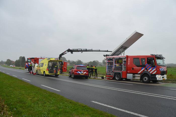 Auto raakt na botsing van de weg en belandt op de kop in weiland