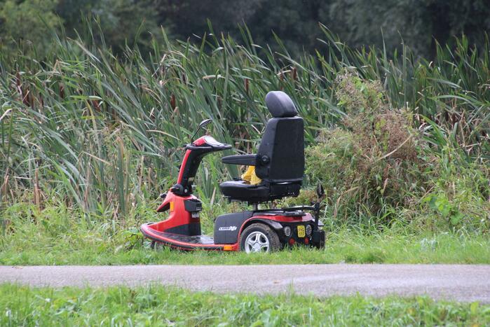 Persoon in scootmobiel raakt te water