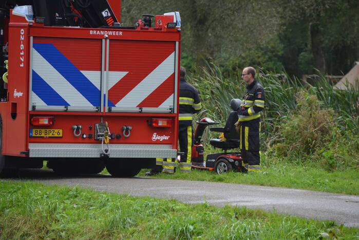 Persoon in scootmobiel raakt te water