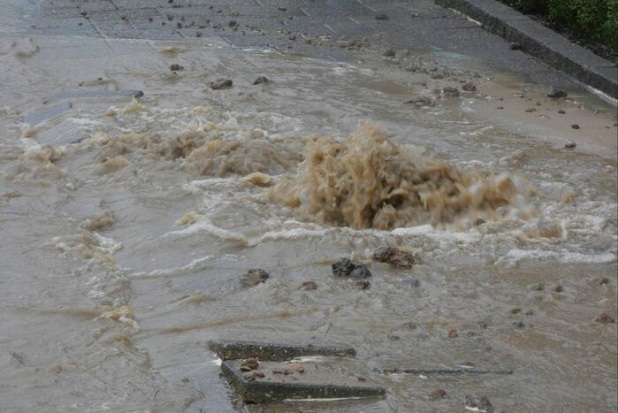 Straat onderwater door gesprongen waterleiding