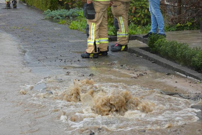 Straat onderwater door gesprongen waterleiding