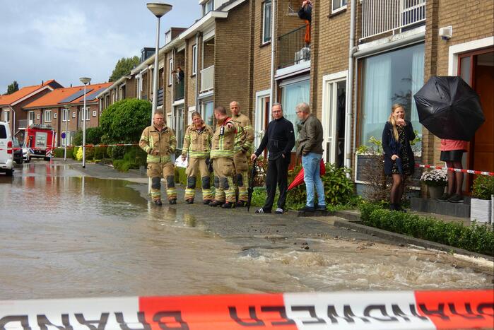 Straat onderwater door gesprongen waterleiding
