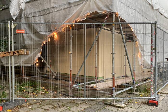 Omstanders blussen brand op bouwplaats