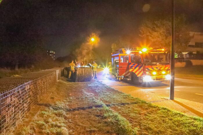 Broeiende hooibalen uit elkaar gehaald