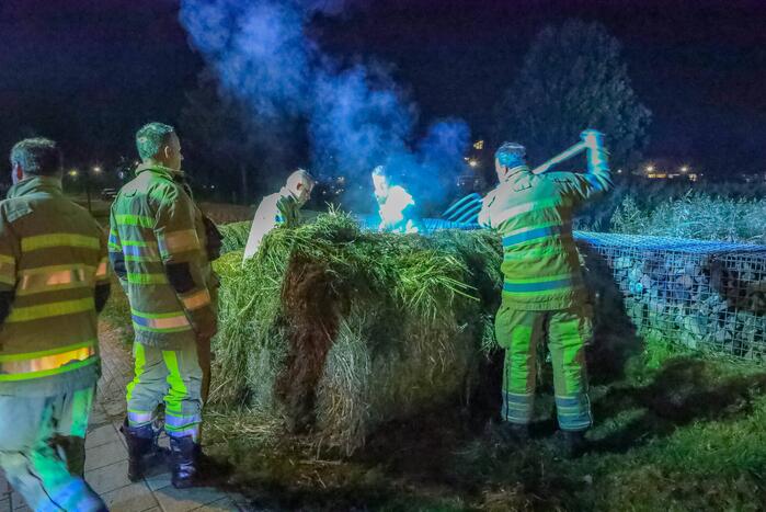 Broeiende hooibalen uit elkaar gehaald