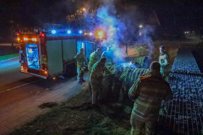Broeiende hooibalen uit elkaar gehaald