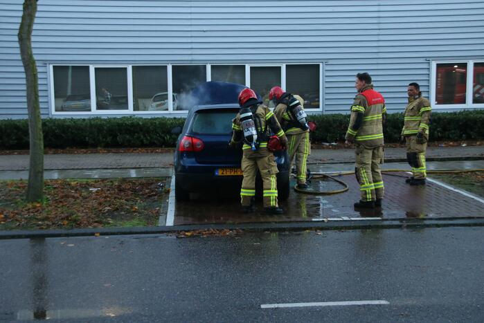Brandweer blust brand in geparkeerde auto