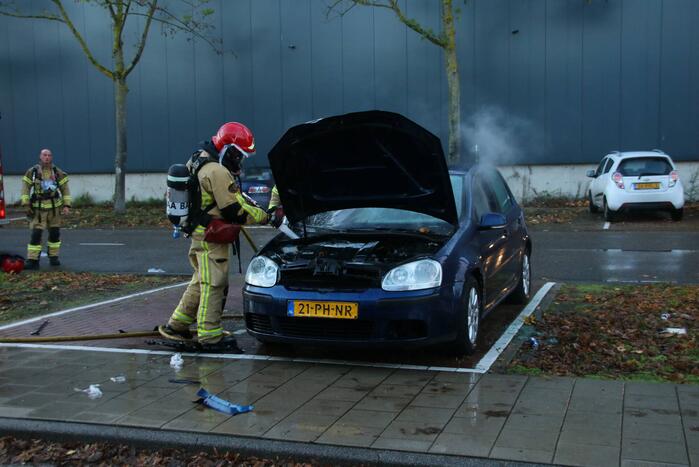 Brandweer blust brand in geparkeerde auto