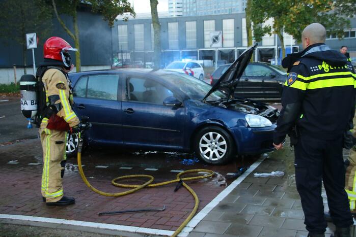 Brandweer blust brand in geparkeerde auto