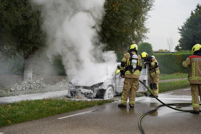 Brandweer blust brand in personenauto