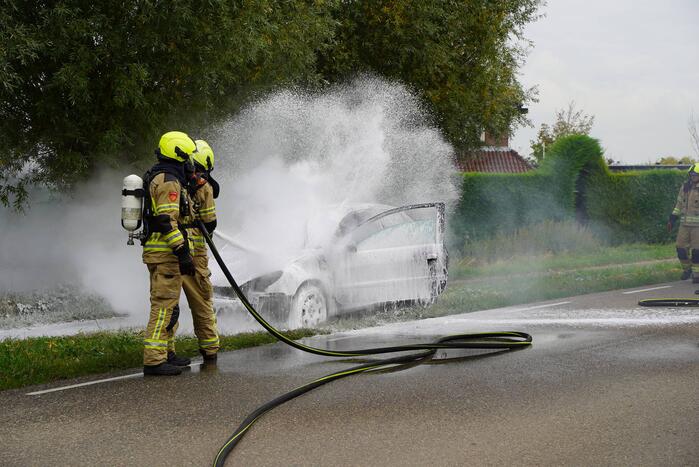 Brandweer blust brand in personenauto