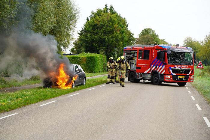Brandweer blust brand in personenauto