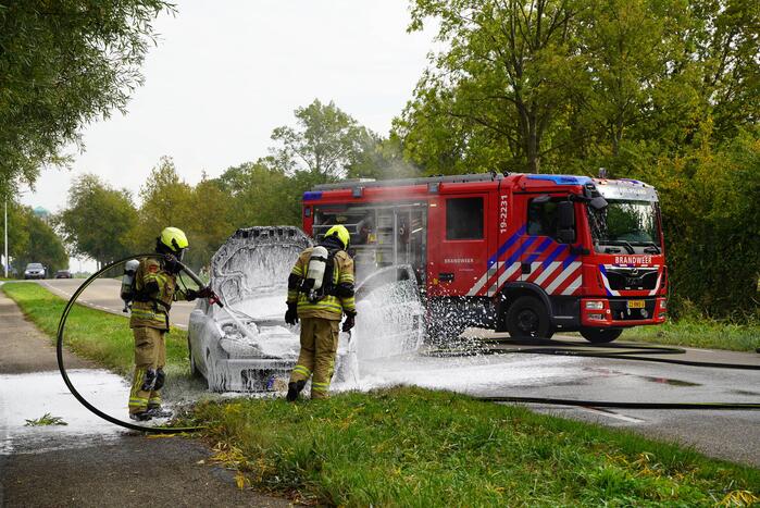 Brandweer blust brand in personenauto