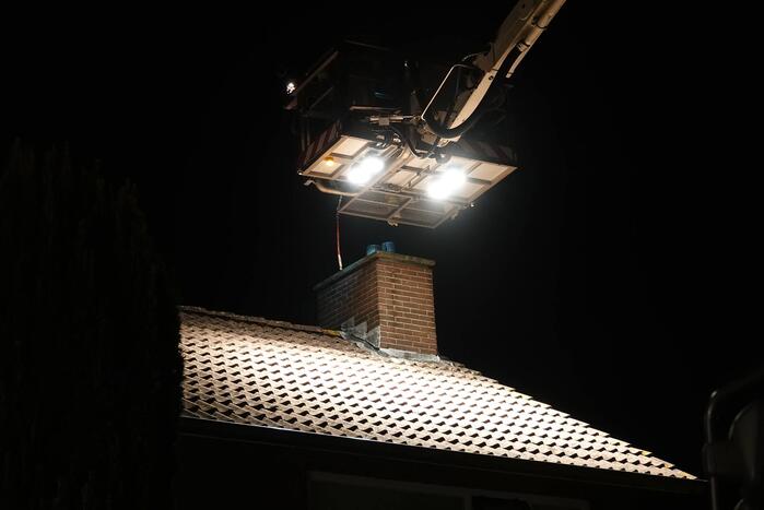 Brandweer veegt schoorsteen na brand