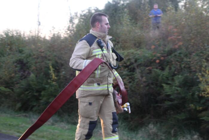 Brandweer blust brandende takken in bos