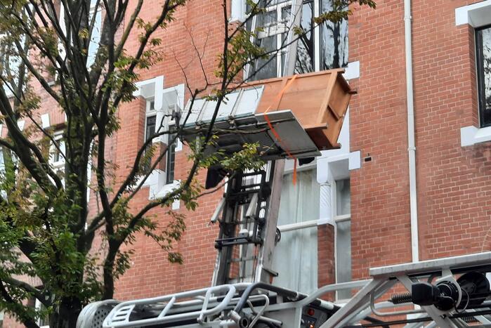 Verhuislift raakt vast in takken van boom