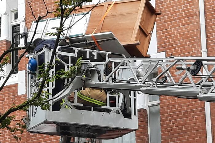 Verhuislift raakt vast in takken van boom